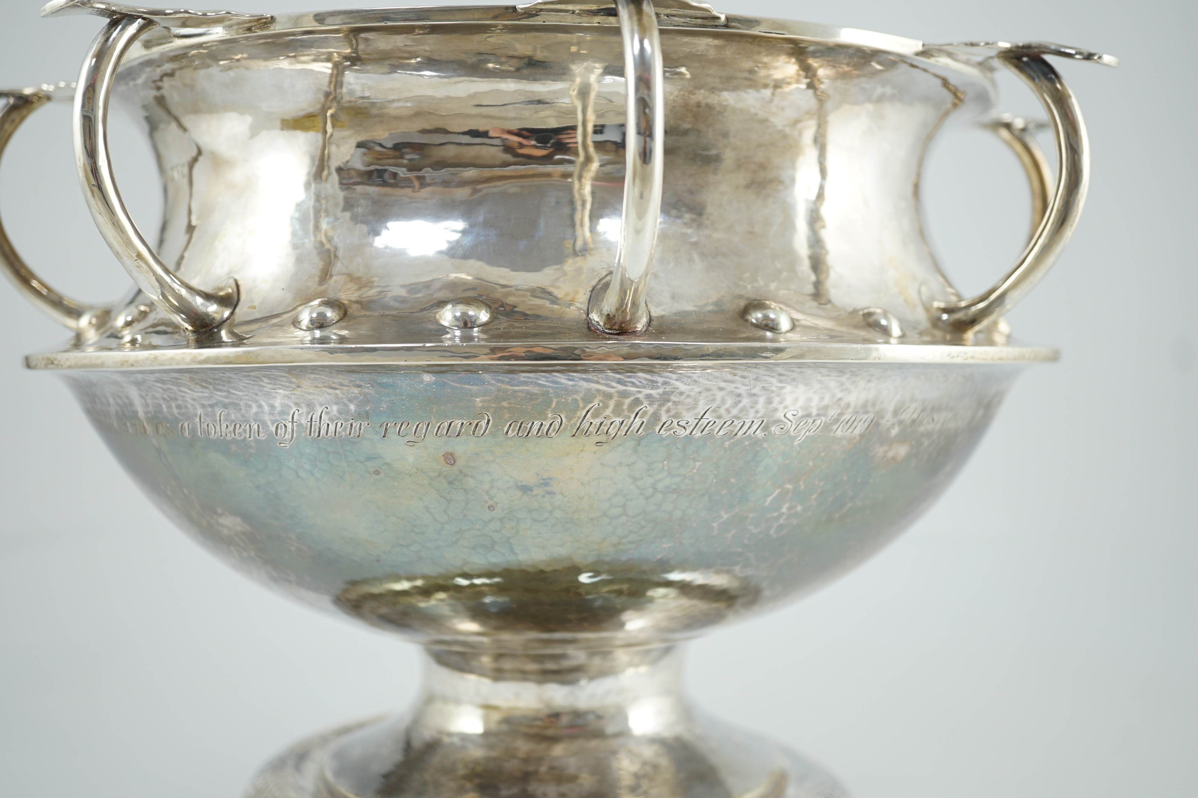 A George V Arts & Crafts planished silver octuple handled pedestal punch bowl, by Albert Edward Jones